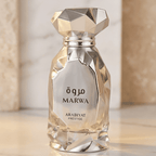 Perfume Marwa da Arabiyat Prestige em frasco facetado dourado e prateado, com colunas de mármore ao fundo.