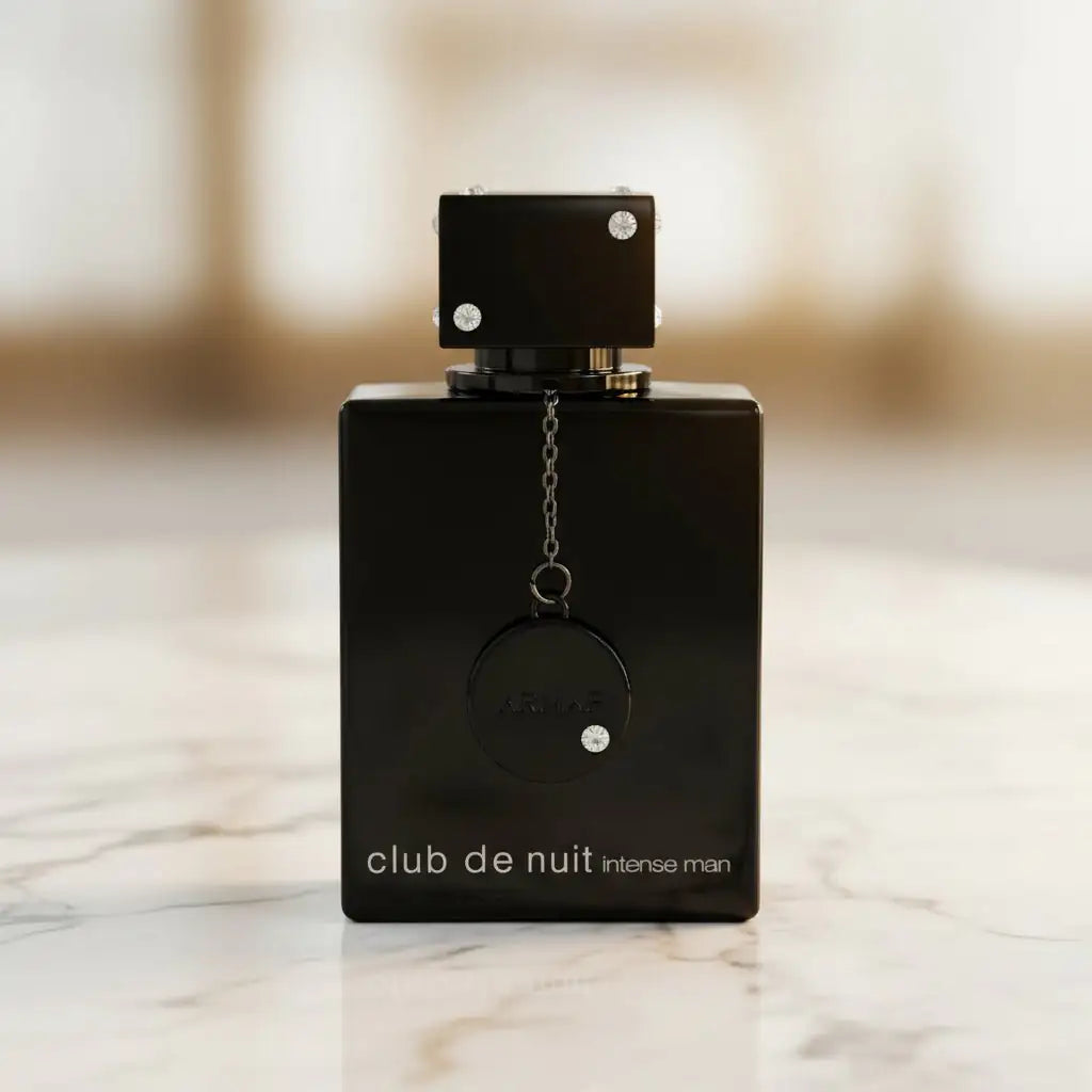 Perfume Club de Nuit Intense Man EDT 105ml da Armaf, frasco preto com pingente, sobre mármore.