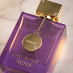 Perfume Club de Nuit Maleka da Armaf em frasco roxo com tampa dourada e pingente pendurado, sobre mármore.