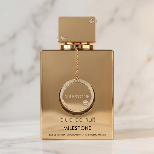 Perfume Club de Nuit Milestone da Armaf em frasco dourado com pingente, sobre fundo de mármore claro.