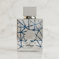 Perfume Club de Nuit Sillage da Armaf em frasco prateado com pingente e detalhe geométrico azul, sobre mármore.