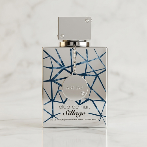 Perfume Club de Nuit Sillage da Armaf em frasco prateado com pingente e detalhe geométrico azul, sobre mármore.