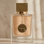 Perfume Club de Nuit Woman da Armaf em frasco transparente com tampa dourada e pingente pendurado.