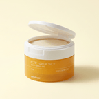 Pote de Pore + Dark Spot Brightening Pad da Celimax aberto, mostrando os discos esfoliantes embebidos em líquido âmbar, sobre fundo bege.