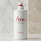 Frasco branco do condicionador Fino Premium Touch com válvula pump, fundo em tons de mármore bege.