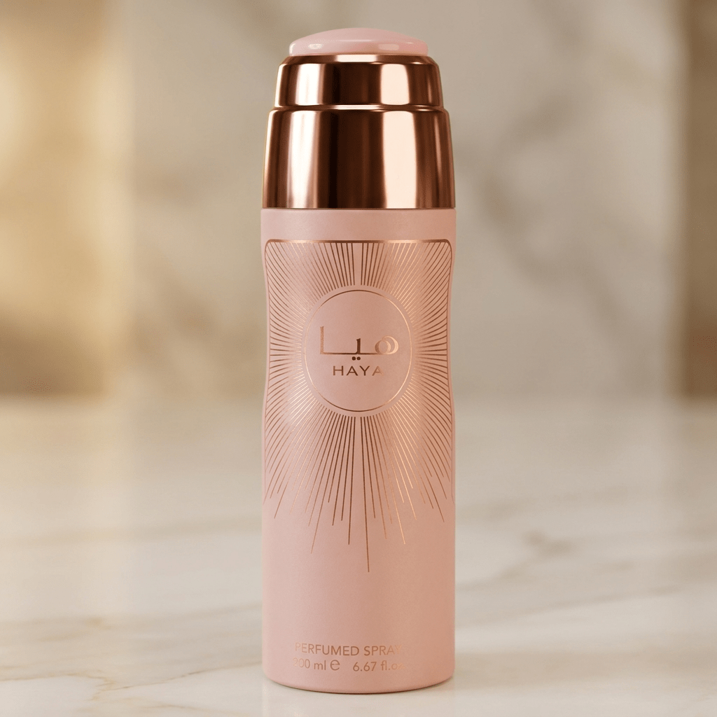 Body Spray Haya, vista completa do frasco rosa com tampa rose gold, sobre fundo bege.