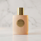 Perfume Cream Velvet, close do frasco rosa canelado com tampa dourada, fundo de mármore desfocado.