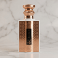 Frasco do perfume Layan Niche Collection da Khalis, em vidro branco com detalhes dourados, isolado sobre superfície de mármore claro.