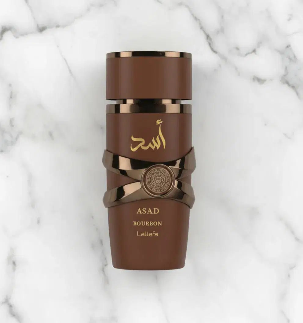 Perfume Asad Bourbon da Lattafa em frasco marrom fotografado de cima sobre mármore branco