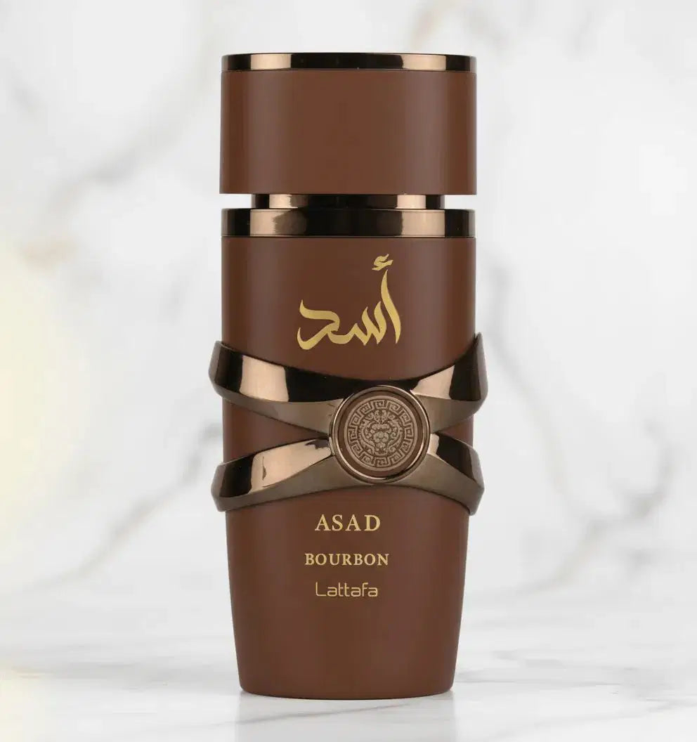 Perfume Asad Bourbon da Lattafa em frasco marrom com faixas metálicas cruzadas, vista frontal sobre mármore