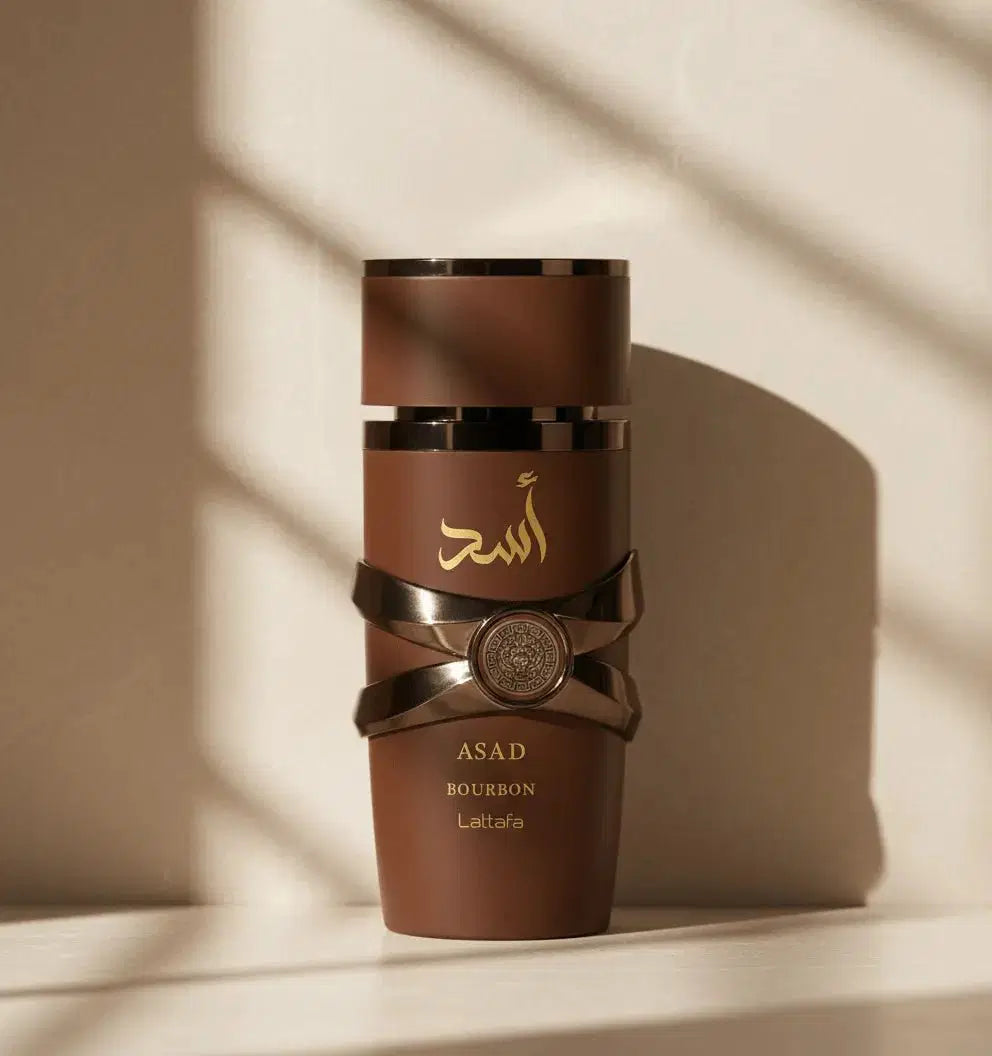 Perfume Asad Bourbon da Lattafa em frasco marrom cilíndrico com detalhes metálicos, sob luz natural
