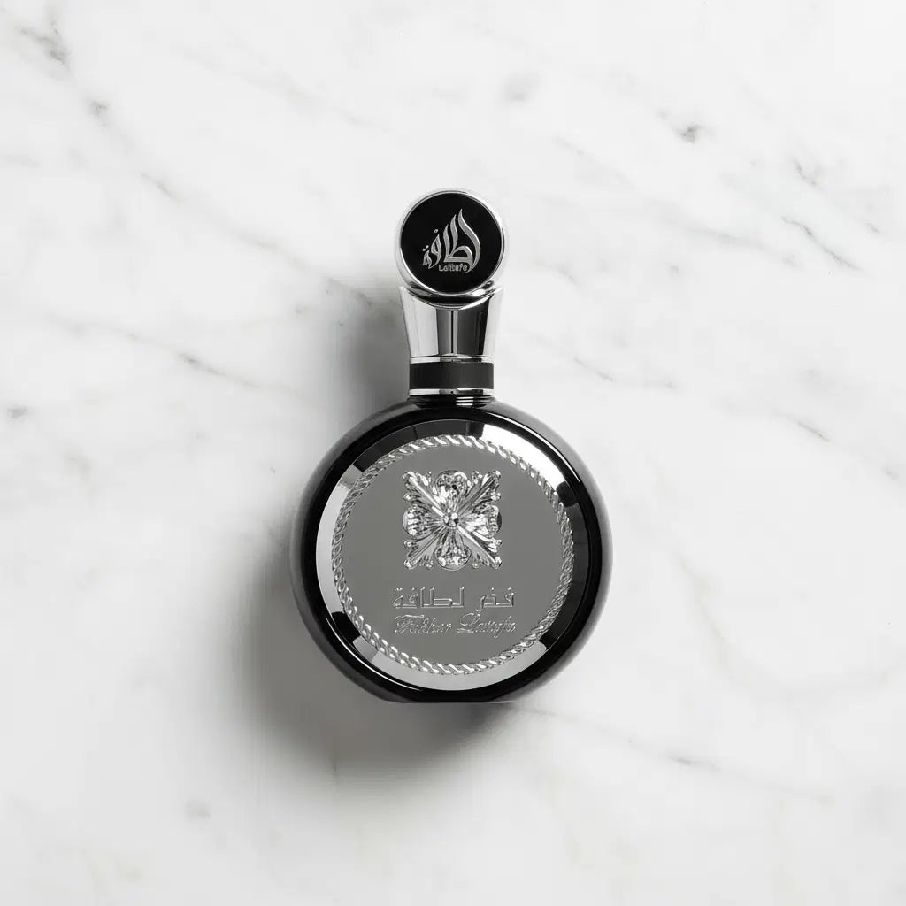 Perfume Fakhar Black da Lattafa em frasco redondo preto com medalhão prateado, fotografado de cima sobre mármore
