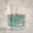 Perfume Khamrah Waha da Lattafa em frasco facetado com líquido azul-turquesa, close-up sobre superfície de mármore