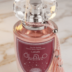 Detalhe do Perfume Mohra Silky Rose, tampa de cristal facetada e laço rosa no gargalo.