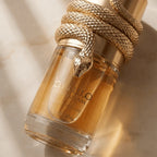 Perfume Musamam White Intense da Lattafa em frasco cilíndrico com tampa em formato de cobra dourada enrolada