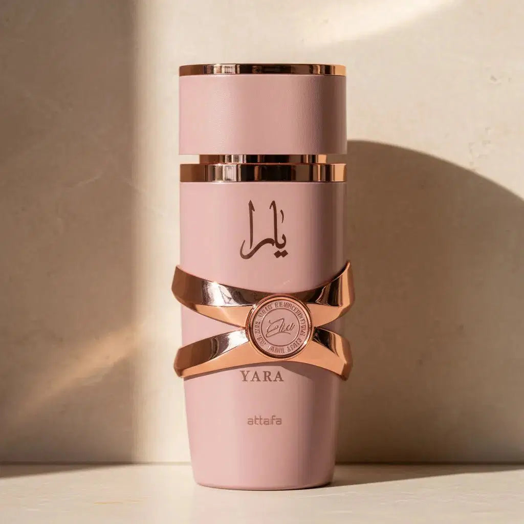 Perfume Yara da Lattafa em frasco rosa com faixas rosé gold cruzadas, sobre fundo com luz lateral
