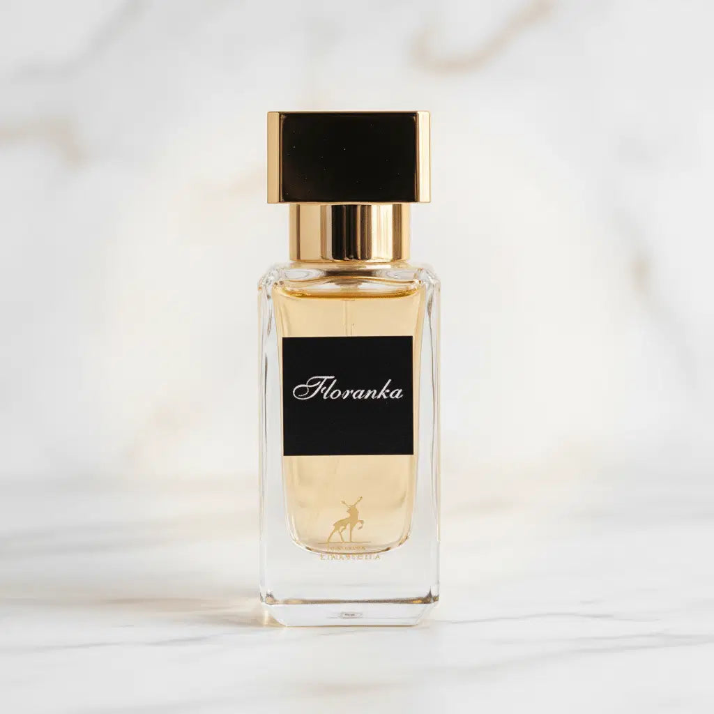 Perfume Floranka da Maison Alhambra em frasco retangular com líquido dourado, rótulo preto e tampa preta com detalhe dourado, sobre mármore claro