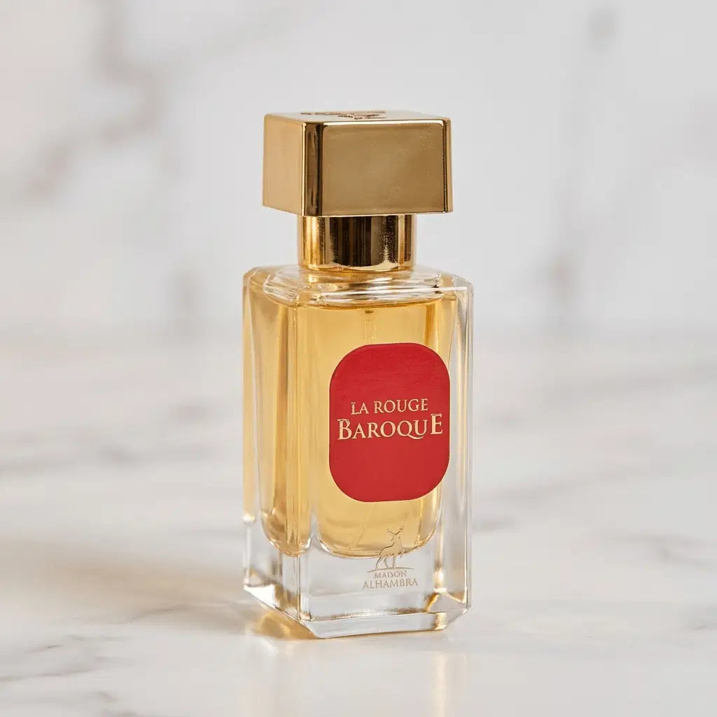 Perfume La Rouge Baroque da Maison Alhambra em frasco quadrado com tampa dourada e rótulo vermelho, sobre mármore claro