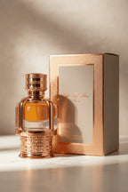 Perfume Al Hambra No.7 da Maison Alhambra em frasco dourado rosé com desenho ornamentado, líquido âmbar, ao lado da caixa rosé original sobre mármore