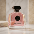 Perfume Pink Eclipse da Maison Alhambra em frasco rosa translúcido com tampa preta, sobre superfície de mármore.
