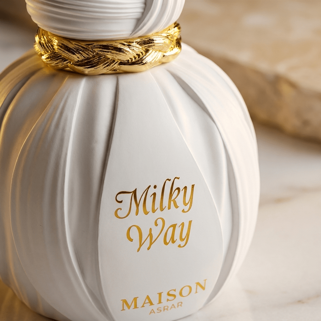Frasco branco canelado do perfume Milky Way da Maison Asrar, com tampa dourada trançada, em close-up de detalhe.