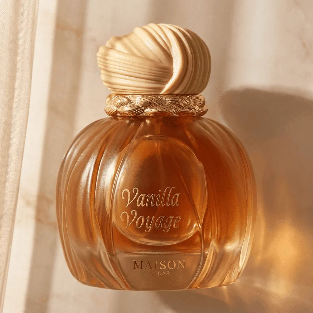Perfume Vanilla Voyage em frasco canelado âmbar com tampa em formato de concha, iluminado a contraluz junto a uma cortina