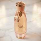 Perfume Mutheer Elixir em frasco rose gold com pingente floral, sobre superfície de mármore.