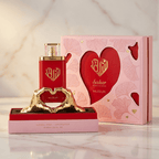 Perfume Saher da Nusuk, frasco vermelho ao lado da caixa rosa com coração, sobre suporte dourado.