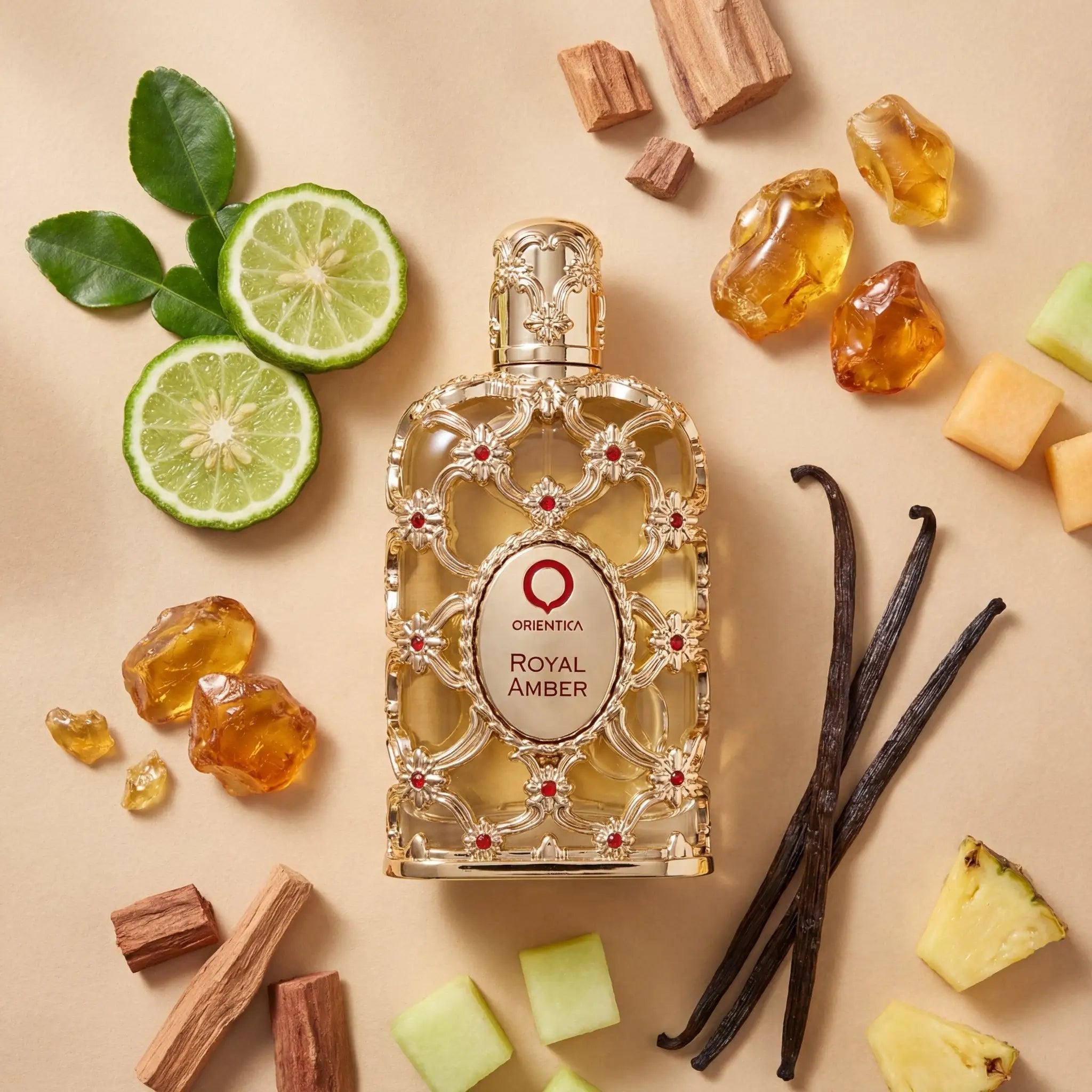 Perfume Exclusive Royal Amber da Orientica em frasco dourado ornamentado, cercado por limão, âmbar, baunilha e madeira.