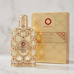 Perfume Exclusive Royal Amber da Orientica ao lado da caixa dourada, sobre mármore claro.