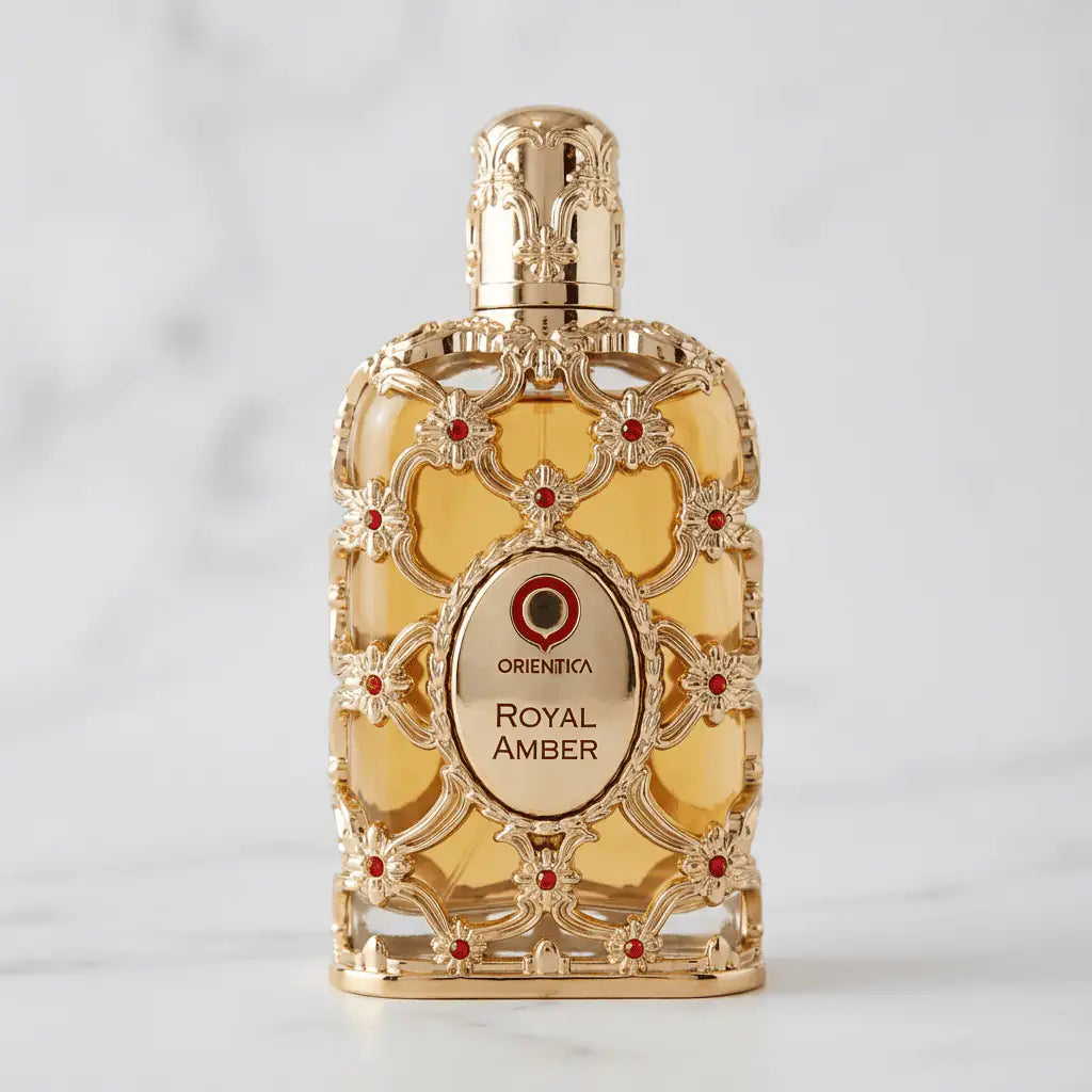 Perfume Exclusive Royal Amber da Orientica em frasco dourado ornamentado, sobre mármore branco.