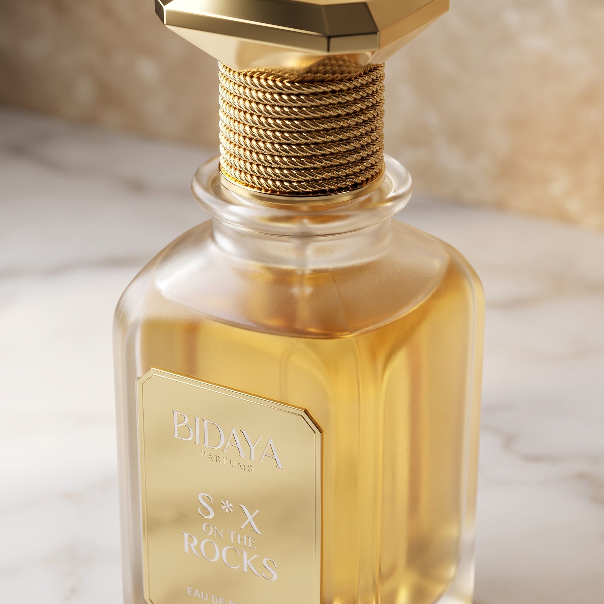 Close-up do frasco Bidaya Parfums S*X on the Rocks, detalhe da tampa dourada trançada e do rótulo