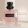 Frasco rosa facetado do perfume Valentino com tampa preta, ao lado de um decant de 5 ml, anúncio de disponibilidade em decant.