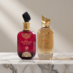 Frascos dos perfumes Sabah Al Ward, em vermelho, e Ameerati, em dourado, lado a lado sobre mármore