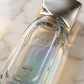 Detalhe da tampa do perfume Nexa Immortal da Rue Broca, frasco de vidro iridescente com acabamento facetado.