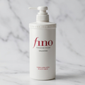 Frasco branco do shampoo Fino Premium Touch em pé, vista frontal, sobre fundo de mármore claro.